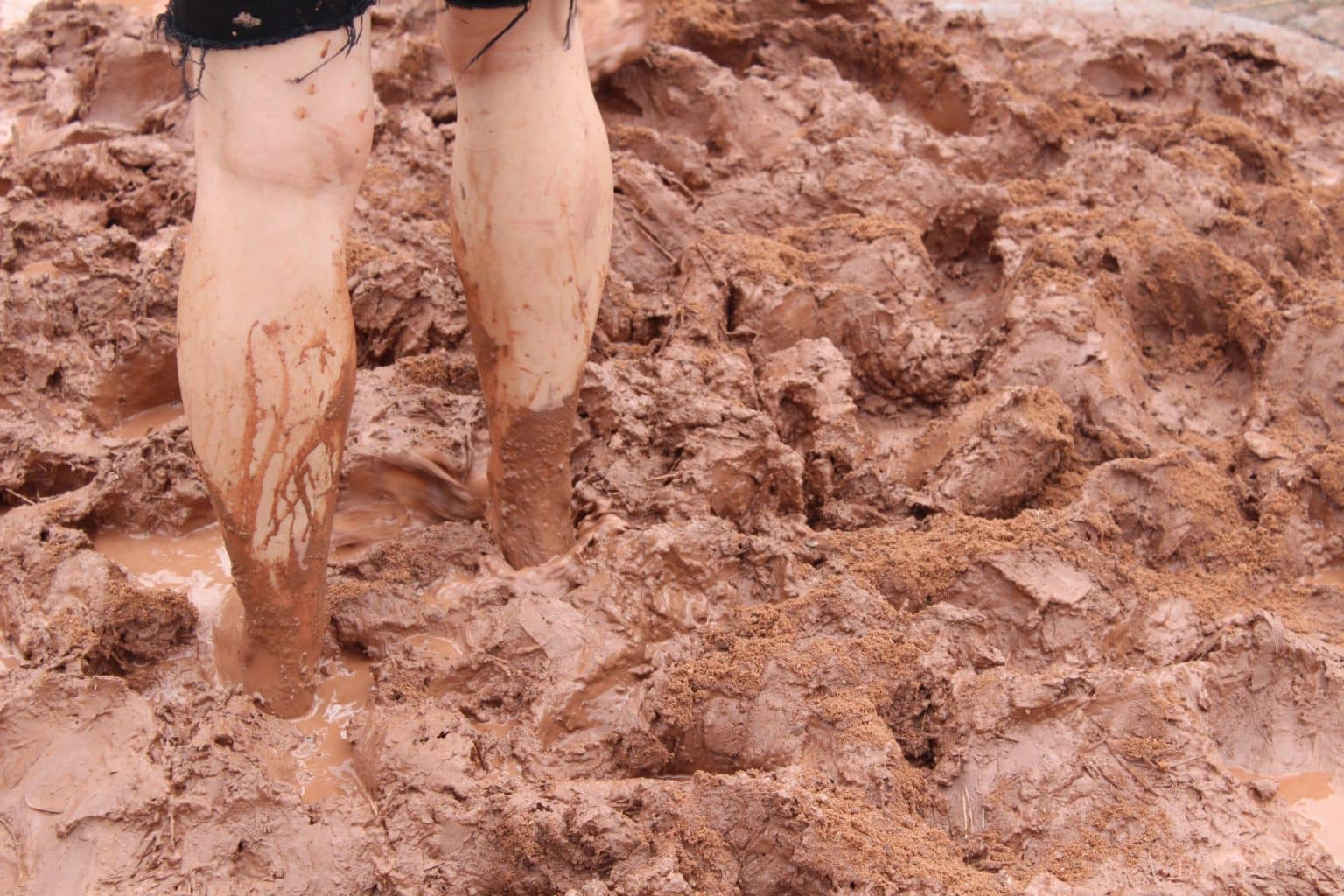 Muddy legs standing in clay